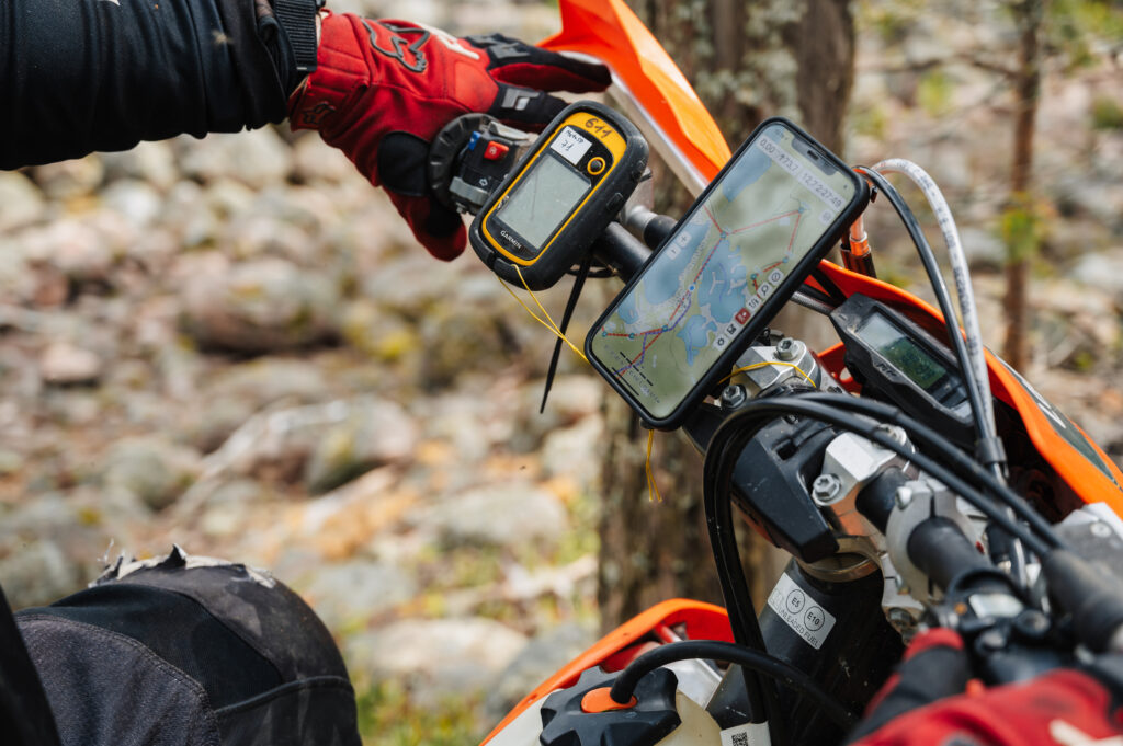 REPUBLIC OF KARELIA, RUSSIA - CIRCA JUNE, 2022: Off-road tournament Ladoga Trophy 2022 in Karelia. Navigator is mounted on the steering wheel of a sports motorcycle for orientation on the map